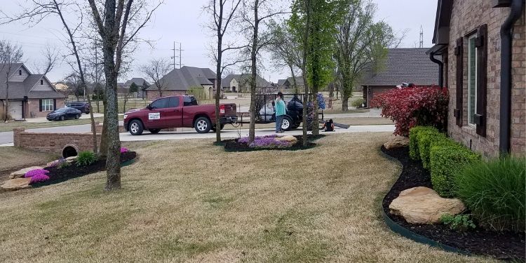 Landscape crew finishing up pruning and mulching a residential home