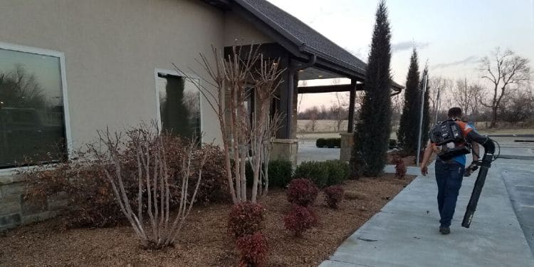 A Sprague's Kik'N Grass employee walks away from a clean commercial mulch bed after a job well done.