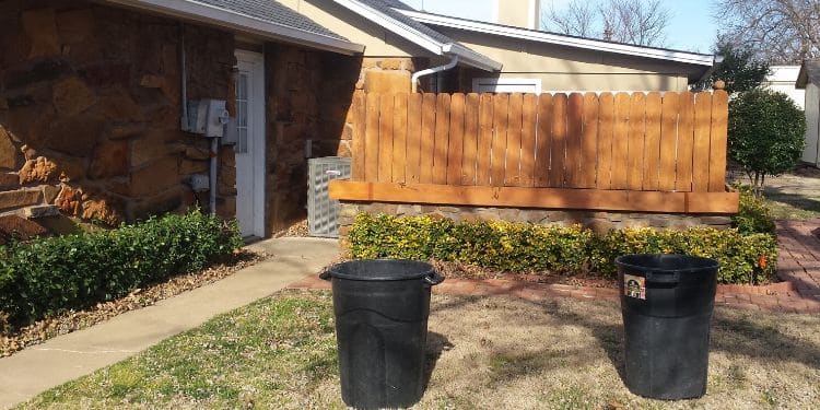 A home and fence lined with recently trimmed shrubs