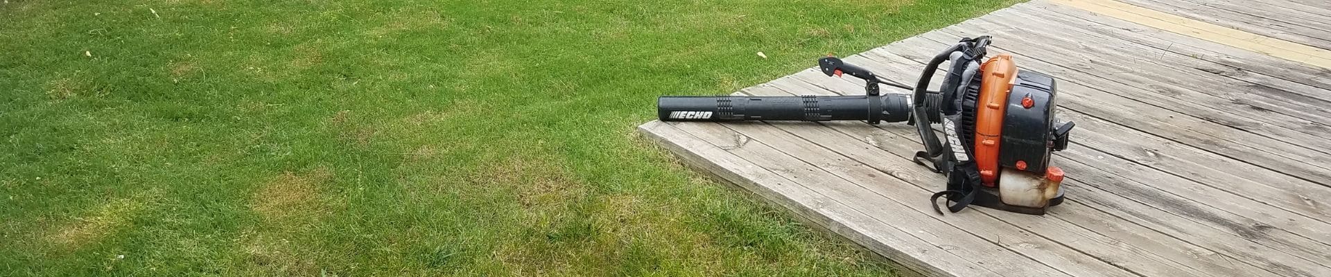 A leaf blower resting on a patio.